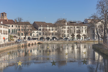 Old palaces with reflections along the river in town Treviso