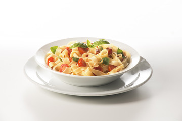 dish with tagliatelle and tomatoes on the white background