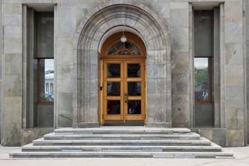 wooden doors in office building. Gray marble facade