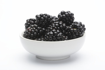 Moras en un bol blanco sobre fondo blanco