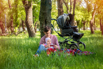 Young father with baby outdoors in park