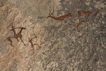 Picture in the cave. On the wall with ocher paints. Caveman hunted animals deer. Neanderthal, primitive, aboriginal, weapons, bow and arrows. The Stone Age, history, science, anthropology