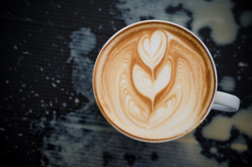 Latte art coffee spill on black background
