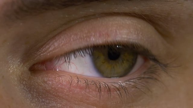 Closeup macro of young man eye blinking and looking around