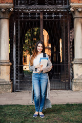 Young student woman with her books outdoors at Uni