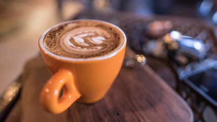 Yummy hot latte coffee on wooden saucer