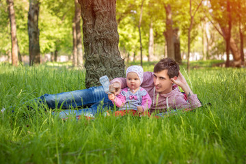Naklejka na ściany i meble Young father with baby outdoors in park