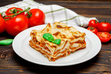 Portion of tasty lasagna on wooden backgound - obrazy, fototapety, plakaty