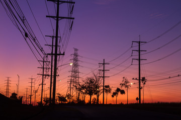 Fototapeta premium The silhouette of the high voltage towers, electricity post and tree which have a beautiful background.