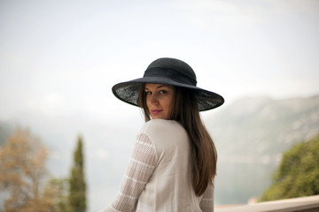 Stylish young woman with beautiful hat and beautiful landscape of background