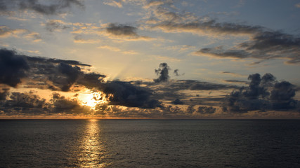 Sunset in ocean: dramatic clouds