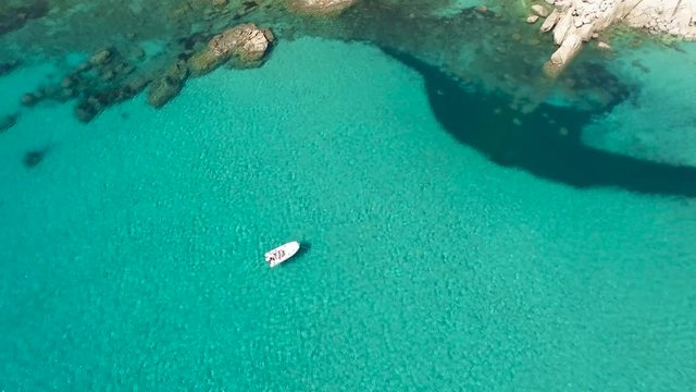 Drone fly over sardinia coastline and colorful turquoise mediterranean sea surraunded by high cliff and ancient ruins of a watchtower