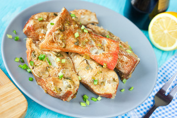 Steamed snapper (pacific ocean perch, sea bass, ruby perch) with soy sauce, lemon, ginger and parsley in Asian style