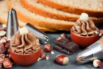 Buttercream with cocoa, chocolate and hazelnuts in small bowls