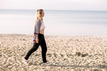 Blonde girl on the beach of the sandy beach by the sea