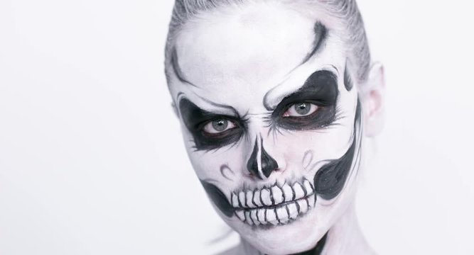 Girl with creative halloween face art on white background.