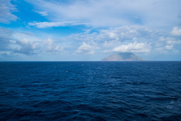 Obraz premium Watching an island from a boat; cloudy day