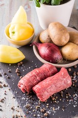Couple of beef slices prepared for roulade on slate board