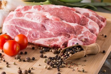 Few pork steaks from neck with color pepper in spoon