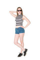 Fototapeta premium Young, pretty teenager standing with blue shorts and colorful bikini top. studio shot on pure isolated white background