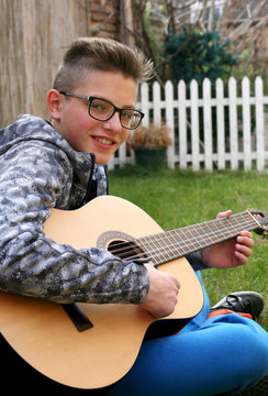  Young man playing on acoustic guitar 