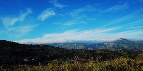 Hills of Sicily. Wonderful autumn day. Toned photo. Typical mediterranean landscape. Quiet noone. Sicilian country life. Scenic view of Enna suburbans.