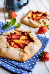 Traditional French Galette pie filled with strawberry and peach