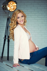 Stylish and beautiful pregnant girl is smiling.