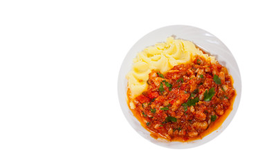 pieces of fish in tomato sauce with mashed potatoes. top view. isolated on white