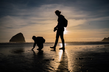 silhouette of mom and son at the beach at sunset