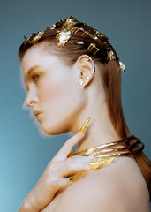 Motion blur beauty portrait of young fashion model with golden make-up and metallic gold nails on...