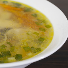 Plate with fish soup in a square arrangement