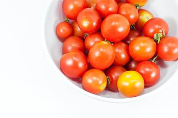 Ripe cherry tomatoes in a bowl on white background