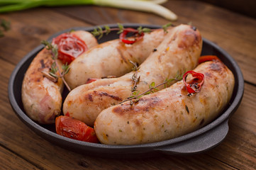 Grilled sausages in frying pan. Wooden background. Top view. Close-up