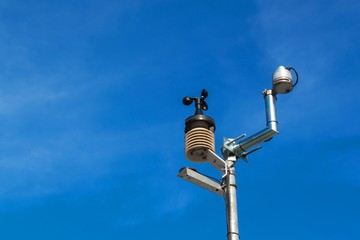  Anemometer on blue sky. Weather measuring instrument wind cup meter and direction.