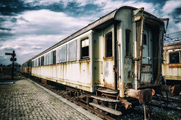 vintage looking photo of rusty old railcars and trains on an abandoned rail platform