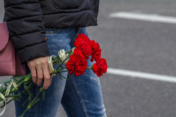 Bouquet of carnations in a female hand. Red carnations as a tribute to the veteran of the great Patriotic war of 1941-1945