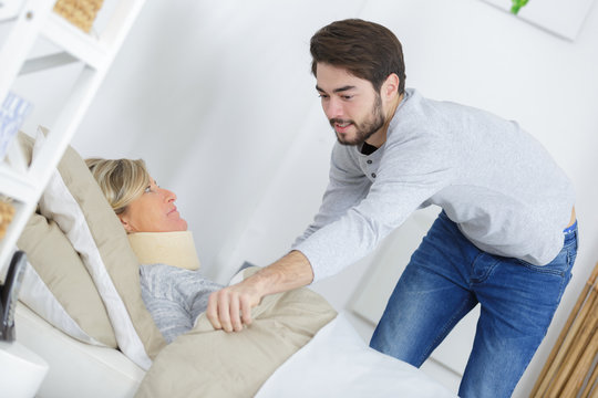 Young man pulling blanket around lady wearing neck brace
