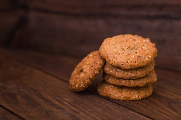 Homemade oatmeal cookies folded in a pile on the old table. Wooden background. Top view. Close-up