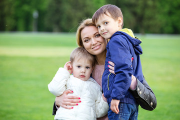 Fototapeta premium Happy young woman hugging sons