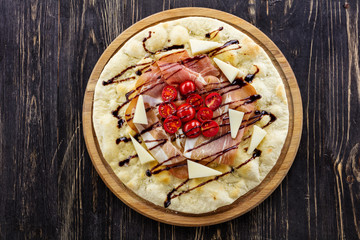 Focaccia with prosciutto, cheese, and cherry tomatoes