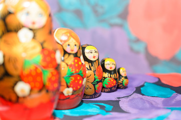 Russian matryoshkas on a light background and a colored background.