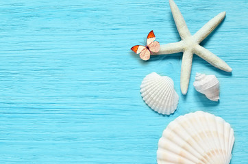 Fototapeta na wymiar Summer sea background - shells, star on a wooden blue background