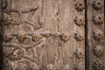 ancient brown wooden door with metallic ornaments