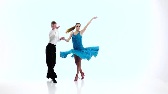 Pair of professional dancers perform rumba, white background. Slow motion