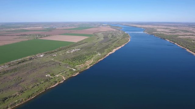 Splendid aerial shot of the Dnipro river with its curvy and indented coastline, wild forests, cultivated fields, patches of greenary, and superb skyscape in Ukraine in a sunny day in spring