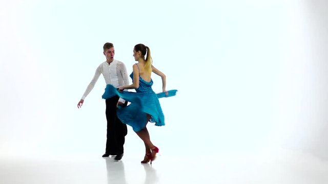 Samba dancing couple of professional elegant dancers,slow motion. White studio