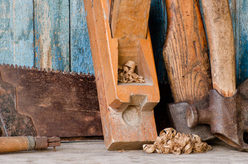 Axes, planer shavings and saw the old blue wooden background. Close up