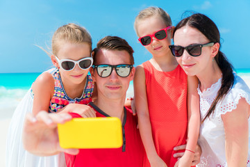 Young family taking selfie portrait on the beach