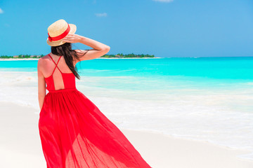 Beautiful woman on tropical seashore. Young girl in beautiful red dress background the sea